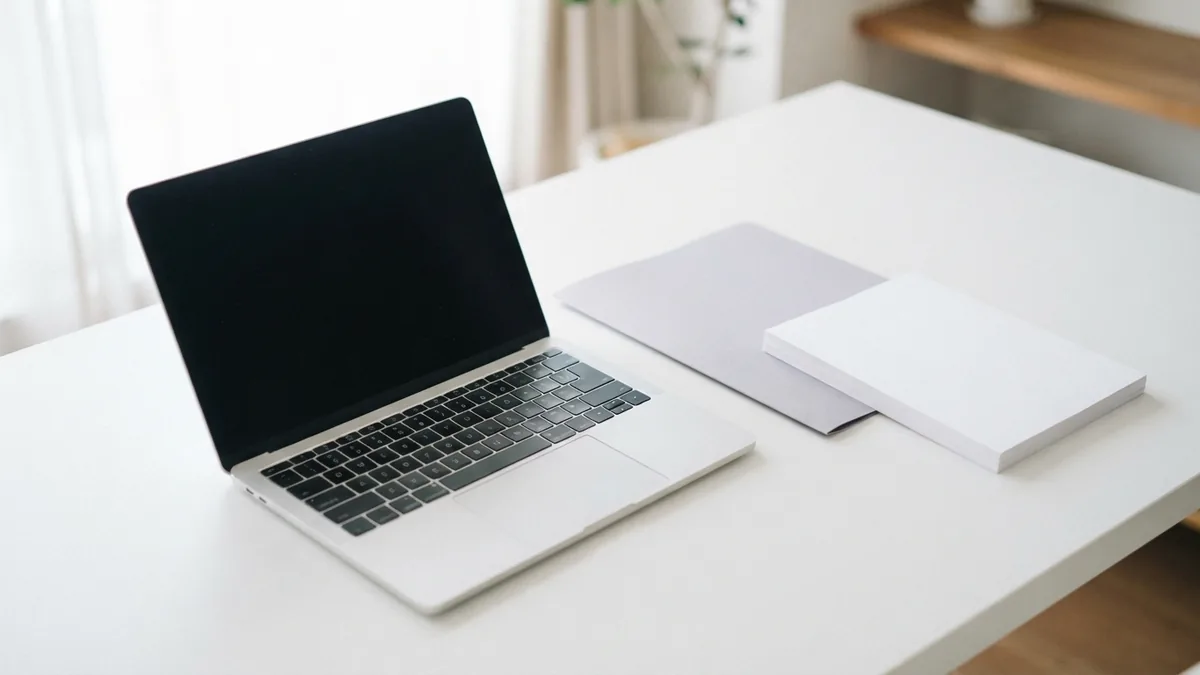 Laptop and folders on a bright desk for locating PDF documents on Mac