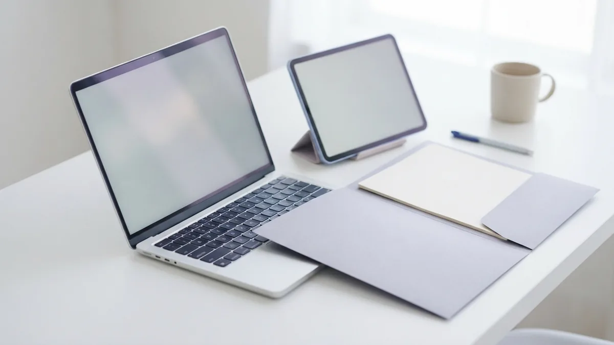 Tablet and laptop beside a blank folder for online PDF signature work