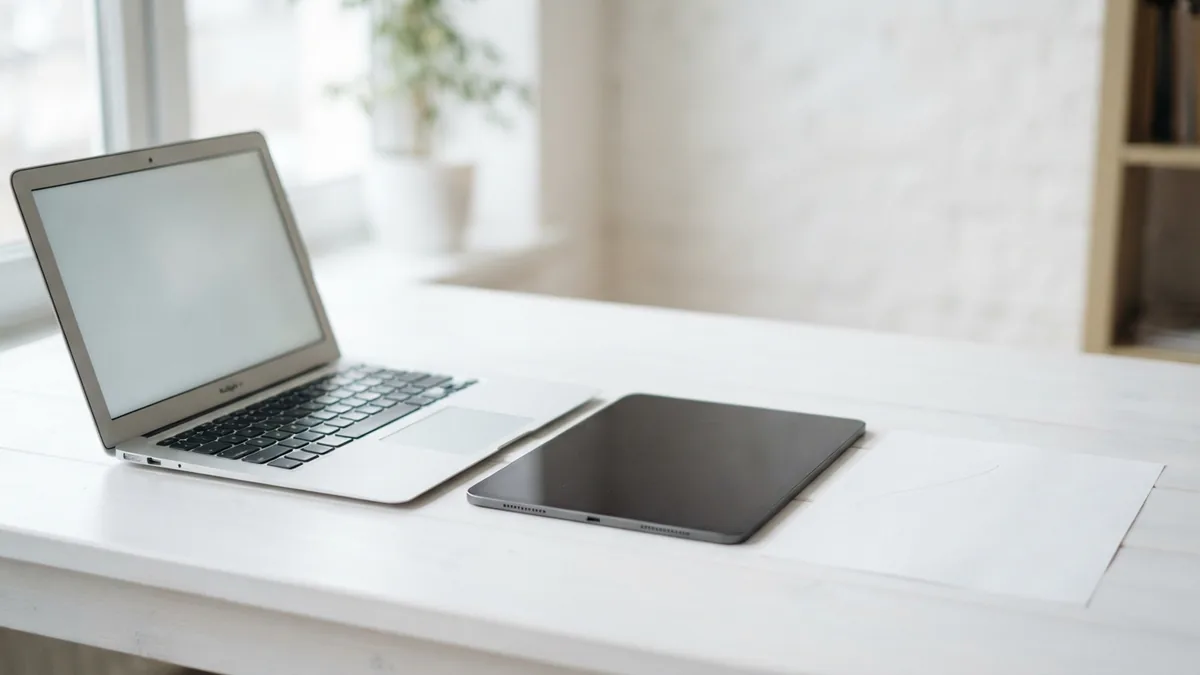 Laptop, tablet, and blank paper showing a tidy cross-device document workflow