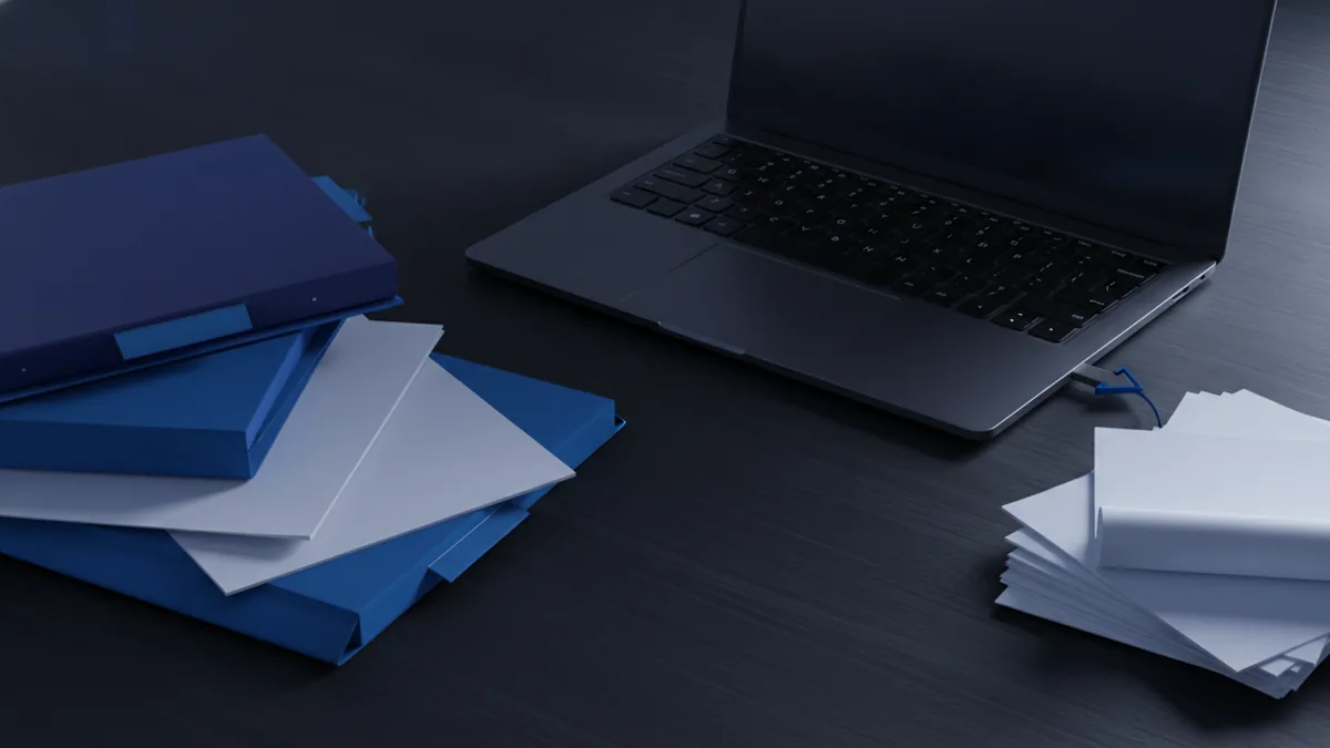 Organized folders and paper files beside a laptop in a tidy workspace