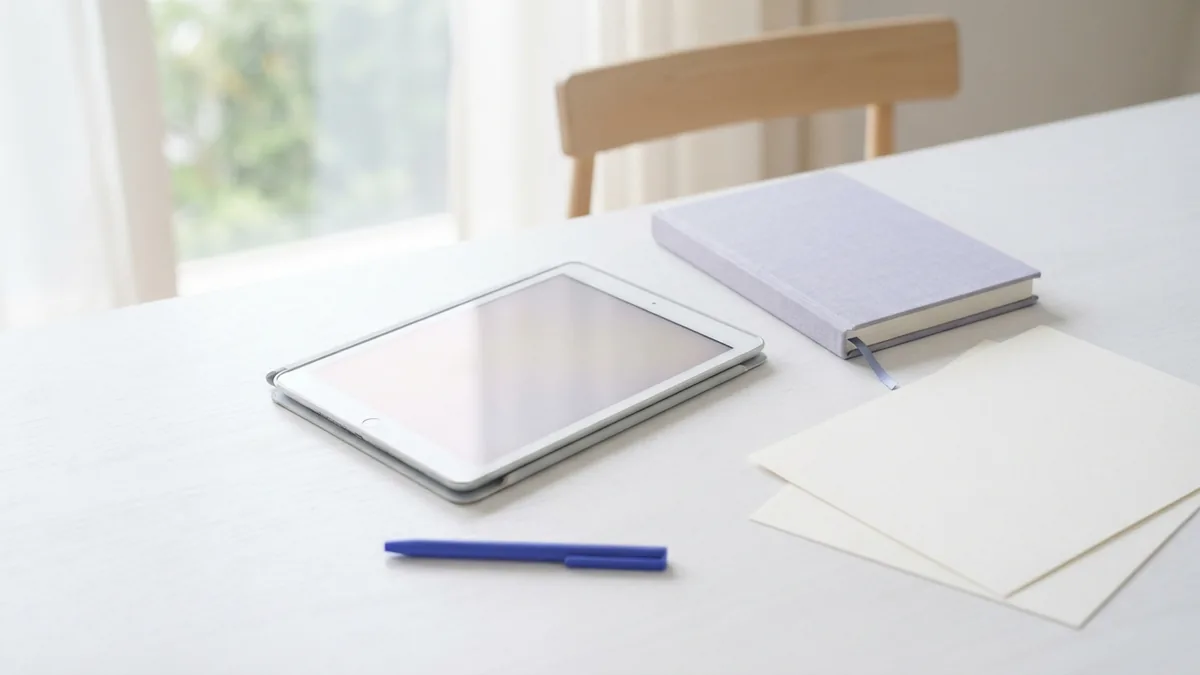 Tablet and book arranged on a bright desk for reading historical writings