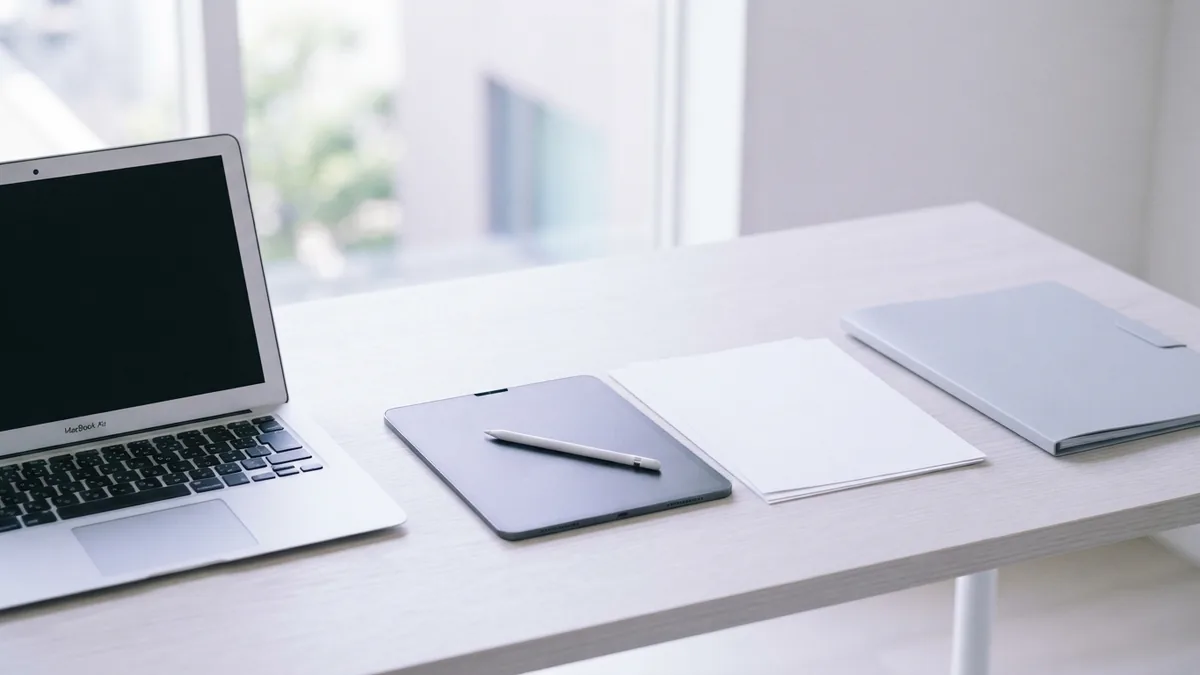 A clean workspace for sharing files Laptop, tablet, and blank document showing a clean file sharing workspace